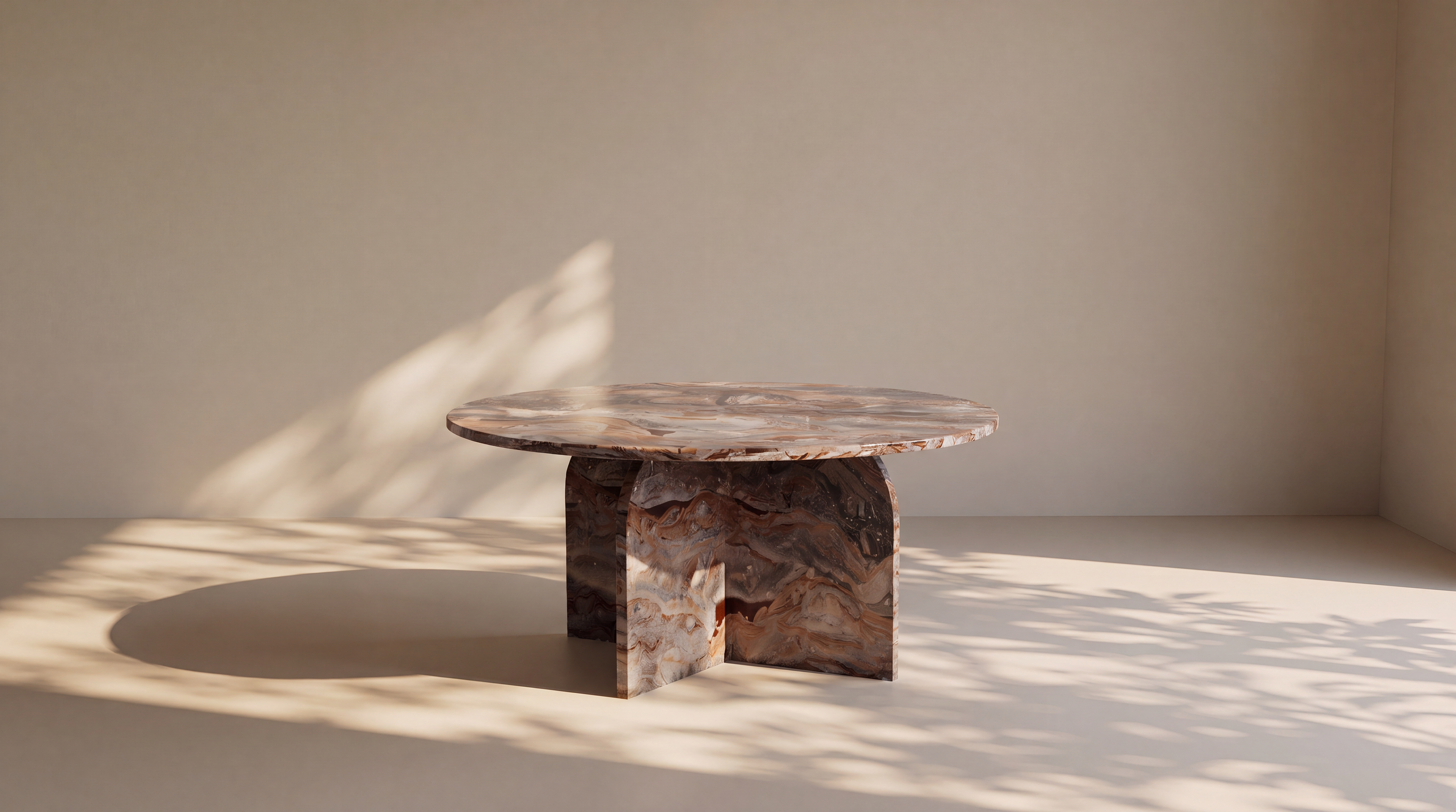 A round stone table with a textured, marbled brown and beige surface, set against a minimalist beige background with soft leaf shadows.